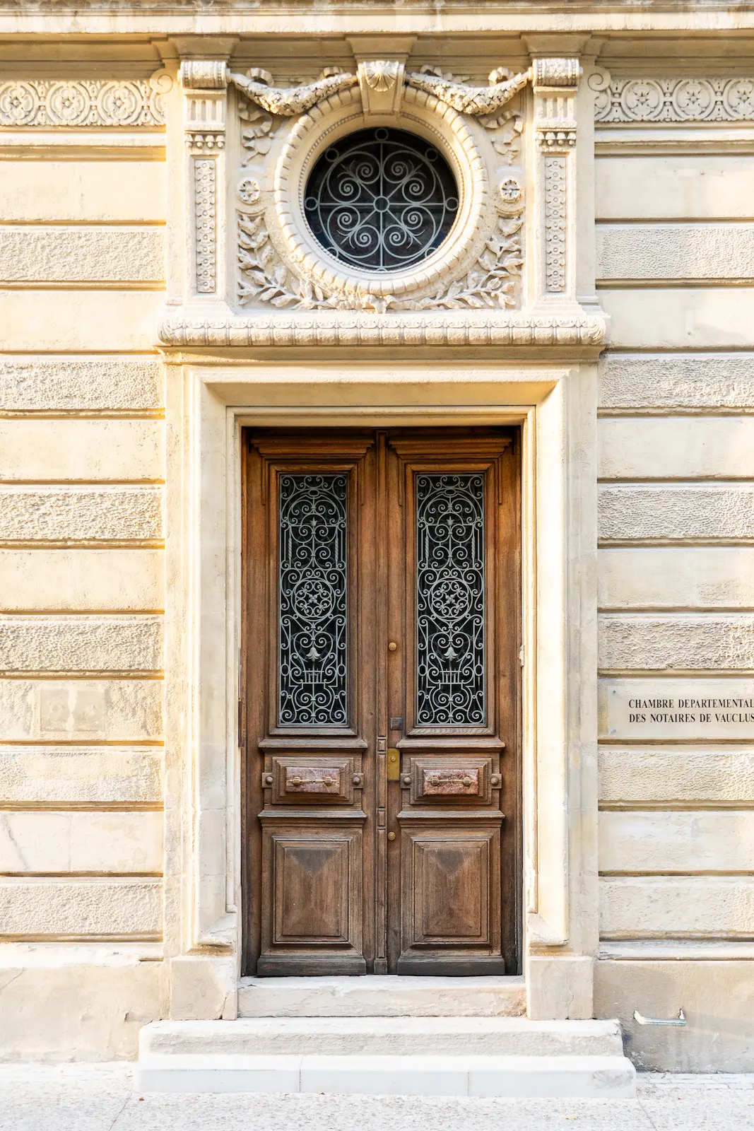Puerta de madera tallada con forja en edificio histórico de piedra, fotografía de arquitectura